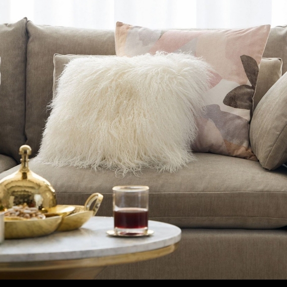 West Elm Mongolian Lamb Pillow Cover on a feather down insert.